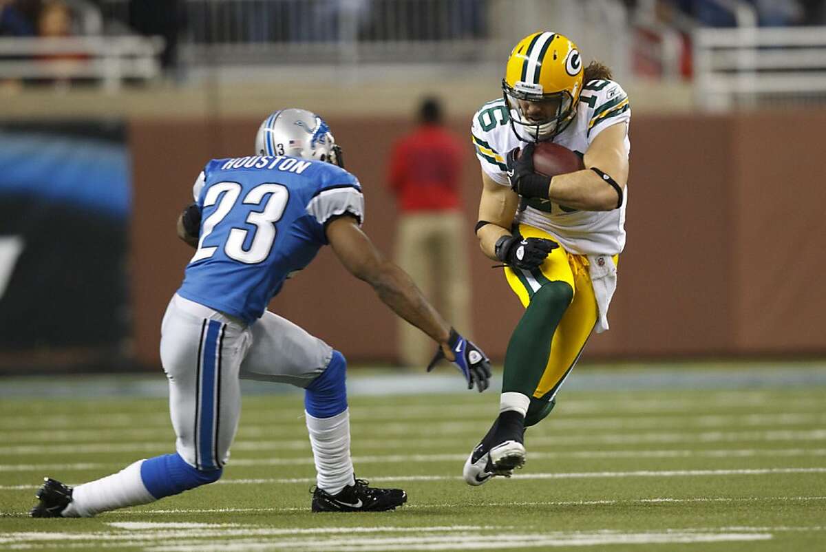 Green Bay Packers wide receiver Brett Swain (16) runs the ball at Detroit Lions cornerback Chris Houston (23) in the first half of the NFL football game against the Detroit Lions in Detroit, Sunday , Dec. 12, 2010. Detroit won 7-3. (AP Photo/Rick Osentoski)