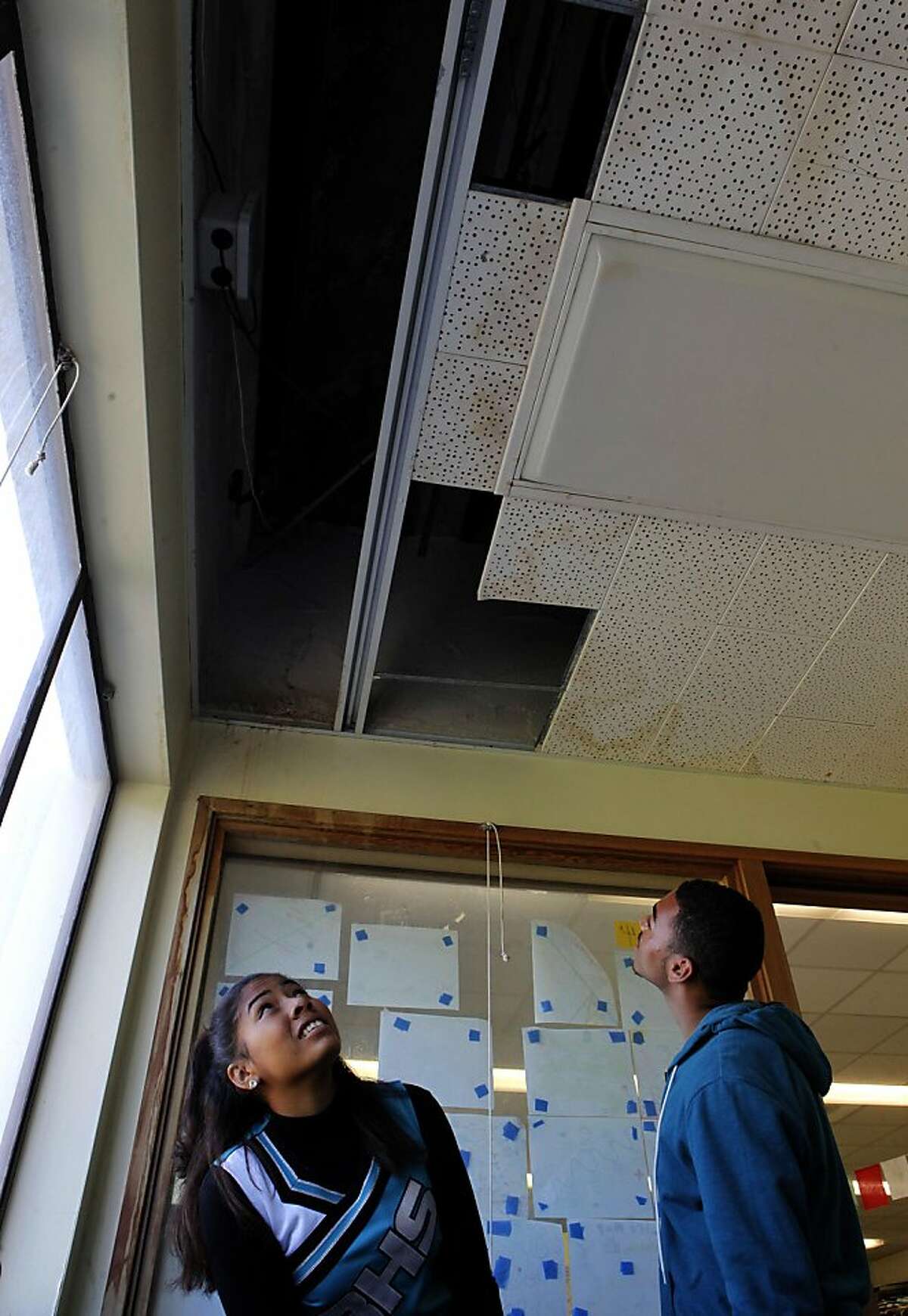 Ashley Milton and Eric Johnson look at the water damaged ceiling of an office inside their classroom, on Friday October 7, 2011, one of the many areas of needed repair at Phillip and Sala Burton Academic High School in San Francisco, Ca. Money would become available if Proposition A were passed in the upcoming elections, funding that would fix the school.
