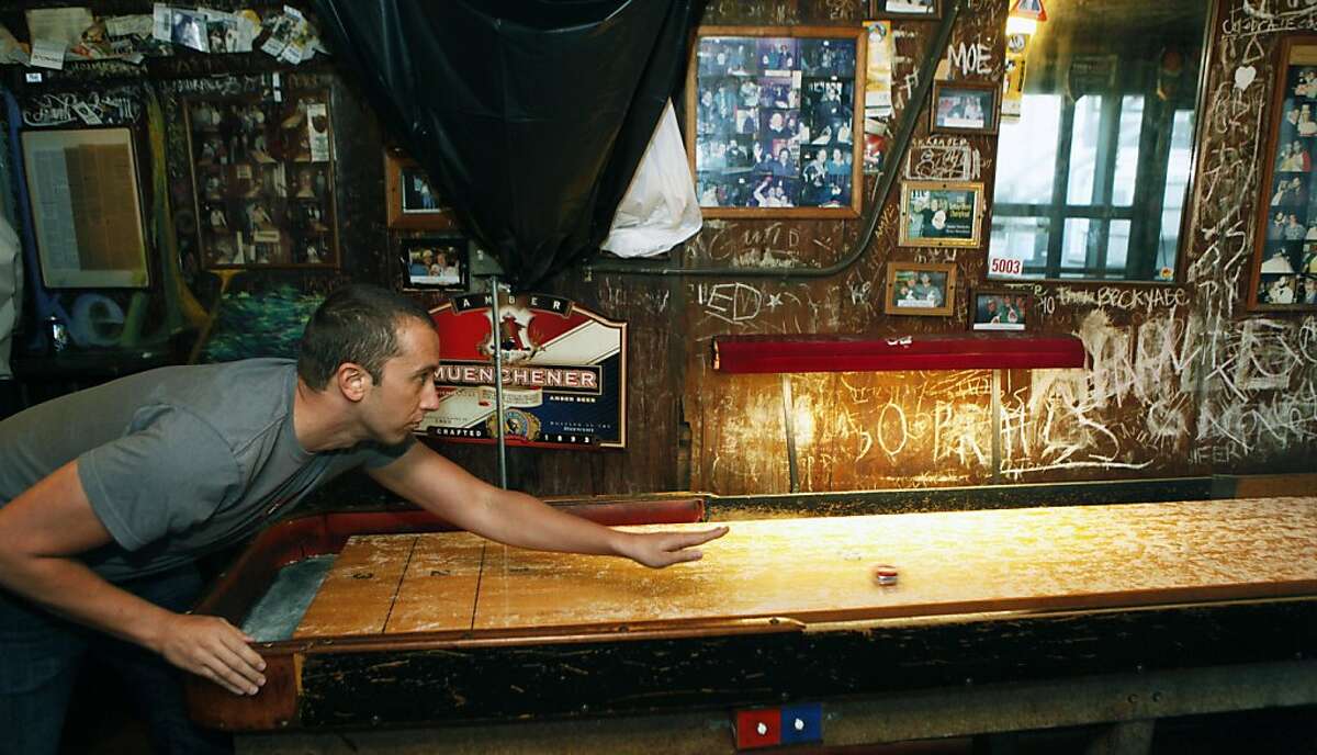 Bryan Maas from Oakland enjoys a game of shuffleboard at the Kingfish. Emil Peinert owner of the Kingfish pub and Cafe has filed to make his very beloved watering hole a Oakland landmark Thursday October 6, 2011.