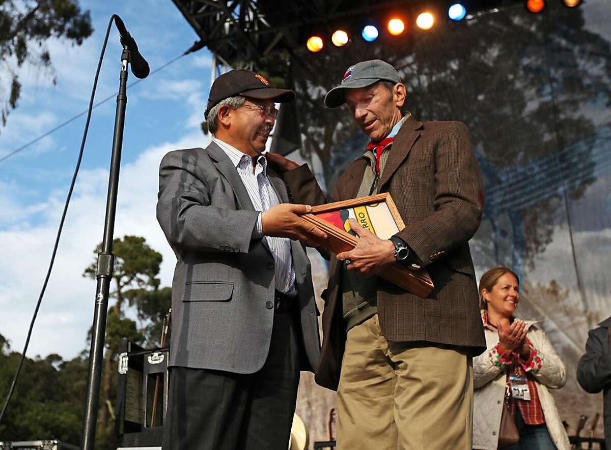 San Francisco Mayor Edwin Lee presents the city's flag to Warren Hellman to commemorate his contribution at Hardly Strictly Bluegrass at Golden Gate Park in San Francisco, CALIF on Oct. 1, 2011. Ran on: 12-16-2011 San Francisco Mayor Ed Lee presents the city flag to Warren Hellman on Oct. 1 to thank him for his civic contributions.
