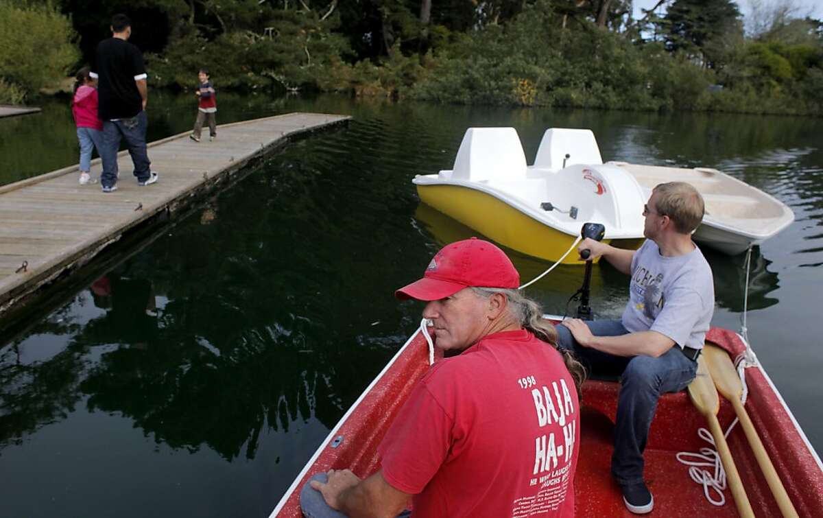 Craig Shaw, left and Andy Bloomfield pull two of the new boats up to the dock from out storage at Stow Lake Boathouse in Golden Gate Park, Tuesday October 11, 2011, in San Francisco, Calif. The new operators, the Ortega Family Enterprise are opening the boat rental and food concession of Wednesday.