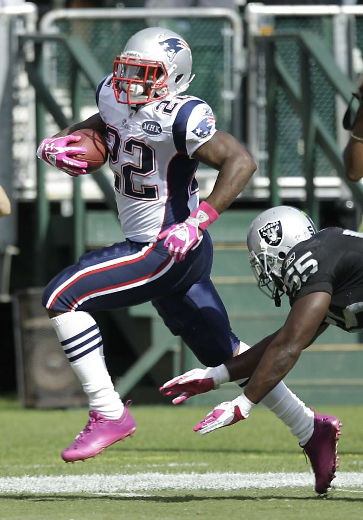 New England Patriots running back Stevan Ridley, left, breaks away from Oakland Raiders linebacker Rolando McClain for a 33-yard touchdown run during the third quarter of their NFL football game in Oakland, Calif., Sunday, Oct. 2, 2011. (AP Photo/Ben Margot)