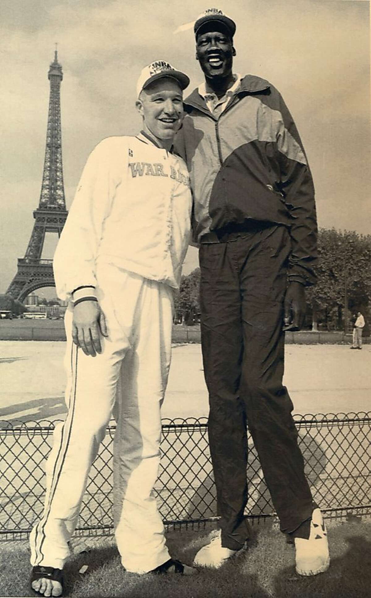 Golden State Warriors guard Chris Mullin, left and Manute Bol pose near the Eiffel Tower in Paris Monday Oct 17, 1994, before Tuesday's game against the Hornets in Paris where the NBA begins a record 11 pre-season games outside the U.S.. AP Photo Michel Lipchitz