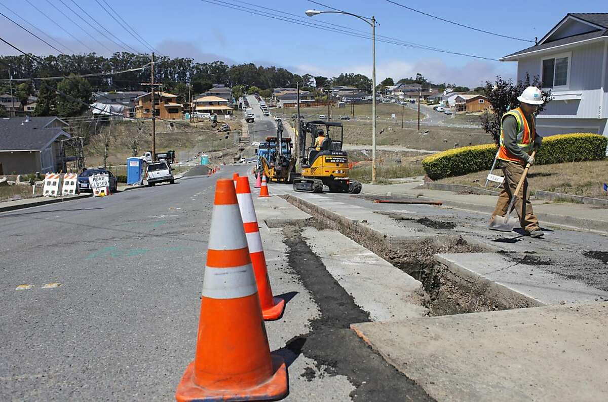 PG&E workers sweep dirt as they fill over a distribution gas line on Glenview Dr. in San Bruno on Thursday August 11, 2011, near the site of last year's blast.