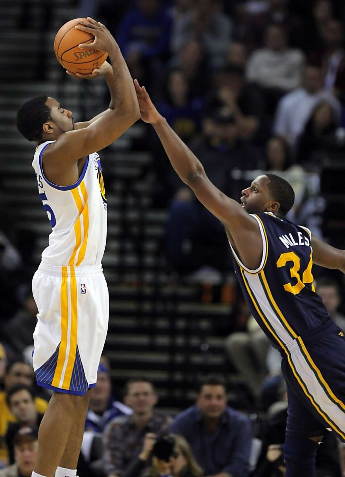 Reggie Williams puts up a shot in the fourth quarter as he is defended by Utah's C. J. Miles at Oracle Arena in Oakland on Sunday.