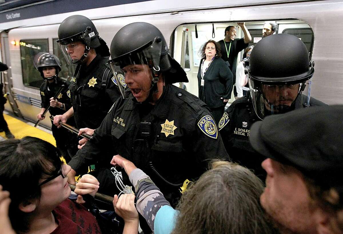 SAN FRANCISCO, CA - AUGUST 15: Bay Area Rapid Transit (BART) police push back demonstrators that are trying to keep a train from leaving the Civic Center station on August 15, 2011 in San Francisco, California. The hacker group "Anonymous" staged a demonstration at a BART station this evening after BART officials turned off cell phne service in its stations last week during a disruptive protest following a fatal shooting of a man by BART police. (Photo by Justin Sullivan/Getty Images)