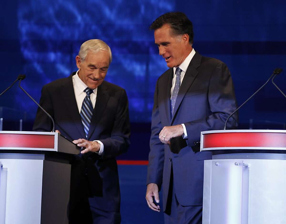 Republican presidential candidates former Massachusetts Gov. Mitt Romney and Rep. Ron Paul, R-Texas talk during a commercial break at the Iowa GOP/Fox News Debate at the CY Stephens Auditorium in Ames, Iowa, Thursday, Aug. 11, 2011. AFP PHOTO / Pool / Charlie Neibergall (Photo credit should read Charlie Neibergall/AFP/Getty Images)