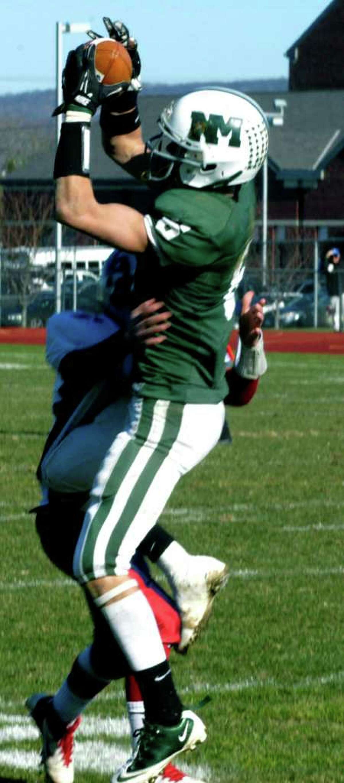 SPECTRUM/Kameron Bradshaw of the Green Wave clutches a deep pass from NMHS quarterback Conor Shanahan on Thanksgiving Day as the New Milford High School football team outlasts visiting New Fairfield, 31-28, to capture the Candlewood Cup. Nov. 24, 2011