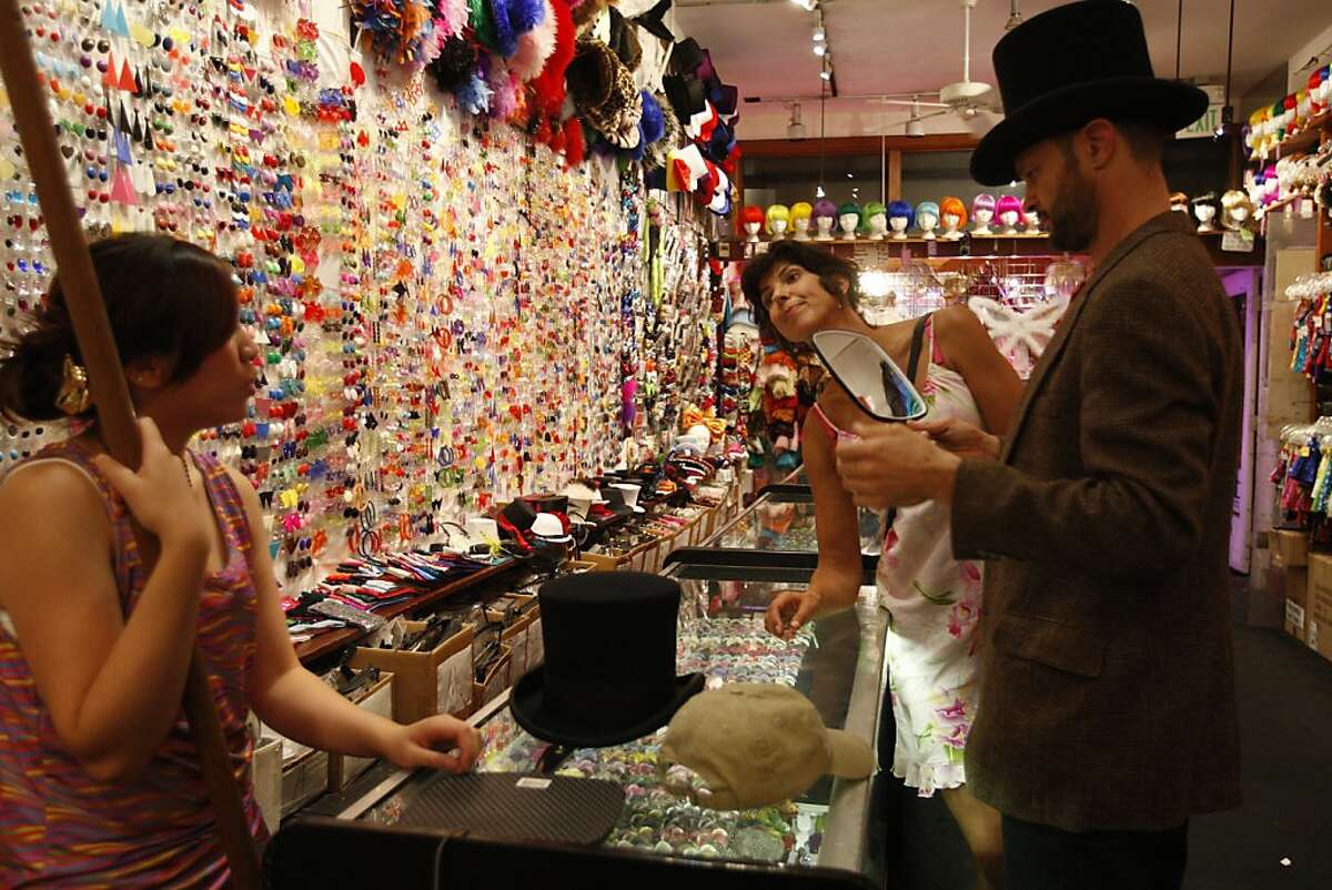 Employee Zerelle Tamayo (left) helps Djoke Steen (center) and Rich Shinne find the right Halloween accessory at Piedmont Boutique in San Francisco, Cailf., on Oct. 14, 2010.