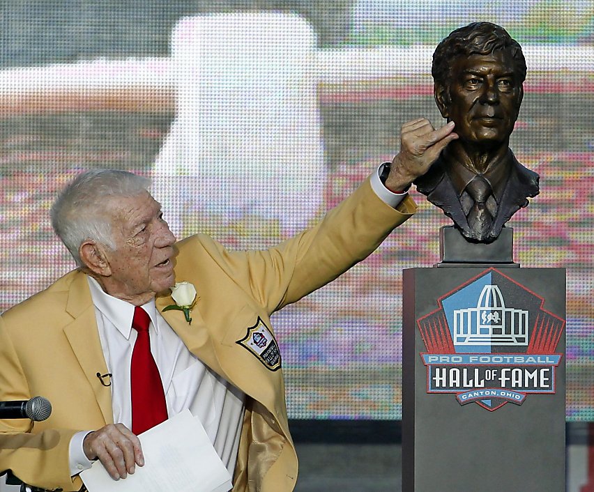Deion Sanders puts a bandana on a bust of himself during the induction ...