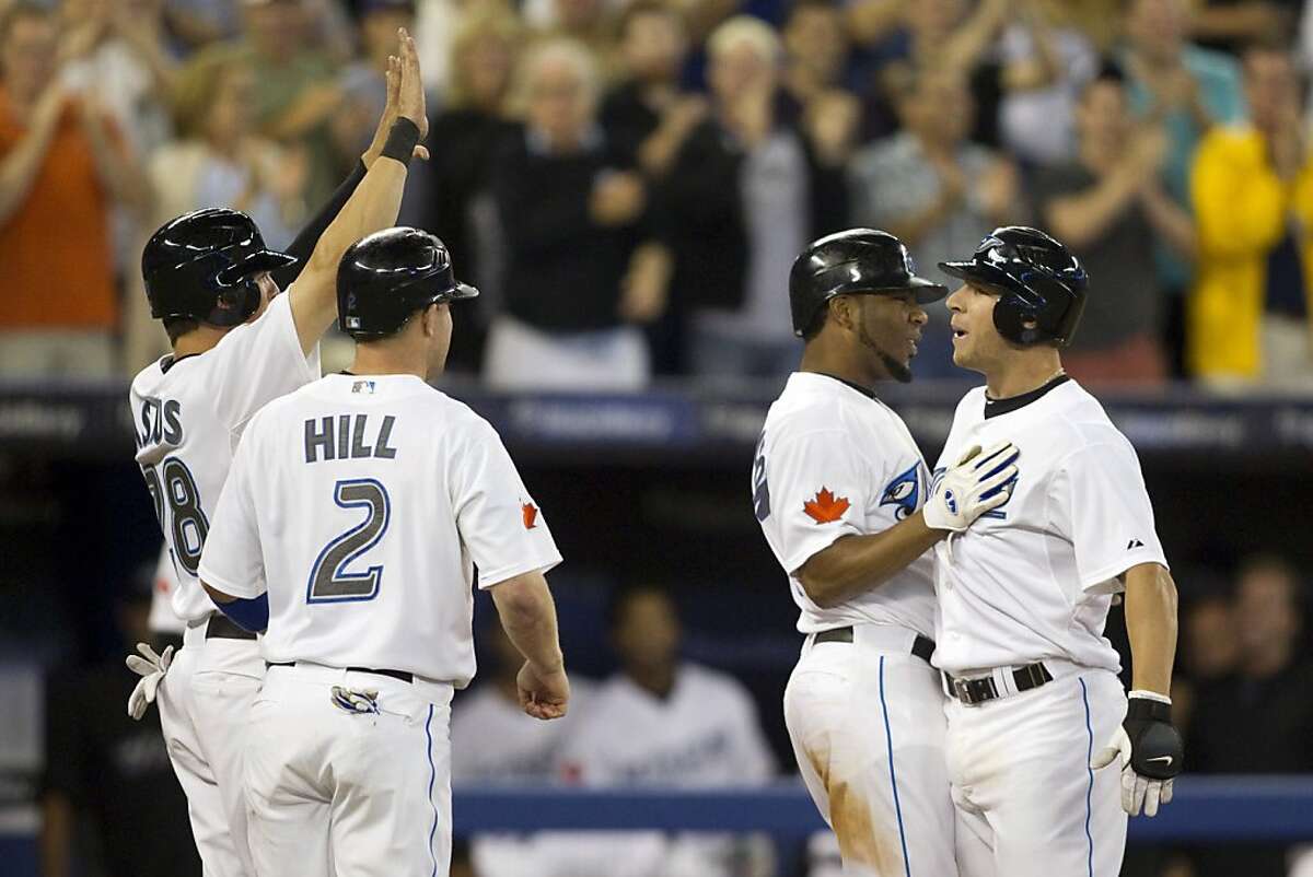 Toronto Blue Jays' Brett Lawrie, right, celebrates his grand slam with teammates, from left, Colby Rasmus, Aaron Hill and Edwin Encarnacion during the sixth inning of a baseball game against the Oakland Athletics in Toronto on Wednesday, Aug. 10, 2011. (AP Photo/The Canadian Press, Chris Young)