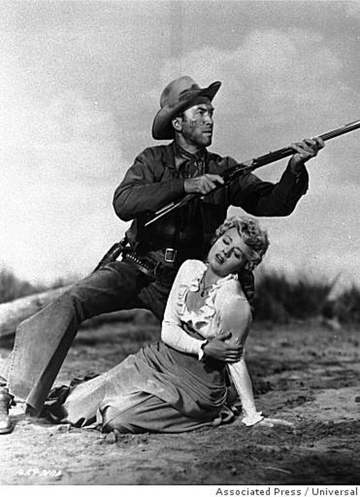 Jimmy Stewart raises his rifle in defense of Shelley Winters in a scene from the 1950 film "Winchester '73".