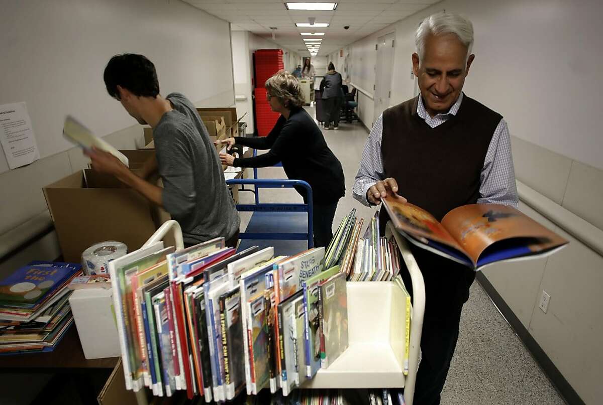 (left to right) Collin Weber, Katrin Reimuller and Saeed Malik, box donated books at the Main Library in San Francisco, Ca. on Thursday August 4, 2011. Saeed Malik a former U.N. official on a trip to San Francisco saw the public library's bookmobile traveling around town which inspired him to launch his own bookmobile in his country of Pakistan. With the help of the library's manager of mobile outreach, Katrin Reimuller, 422 books were donated to Malik's program.