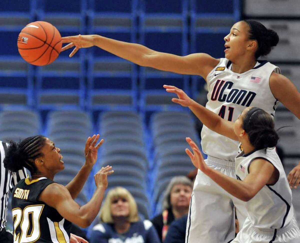 Connecticut's Kiah Stokes, top right, blocks a shot by Towson's Markell Smith, left, as Connecticut's Bria Hartley, bottom right, defends in the first half of an NCAA college basketball game in Hartford, Conn., Wednesday, Nov. 30, 2011. (AP Photo/Jessica Hill)
