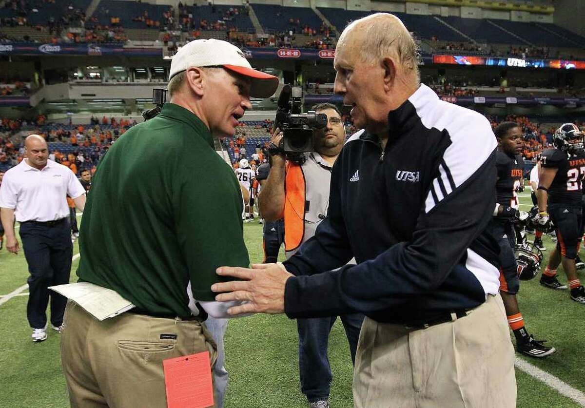 UTSA coach Larry Coker (right), shown shaking hands with Minot State coach Paul Rudolph after the Roadrunners’ 49-7 victory on Nov. 19, can use the fact the Alamodome is UTSA’s home field as a recruiting tool. But the school’s other facilities are not top notch.