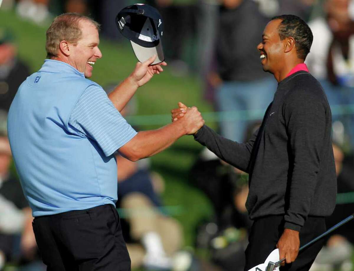 Steve Stricker (left) shakes hands with Tiger Woods after they wrap up their first round at the Chevron World Challenge.