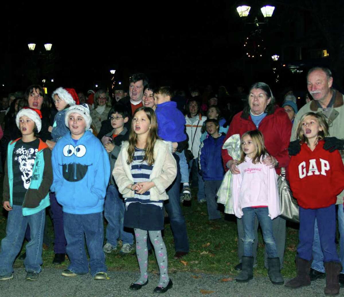 SPECTRUM/Voices of all ages chime in together to sing Christmas songs during the Village Center Organization's Festival of Lights celebration on the Village Green in New Milford. Nov. 26, 2011