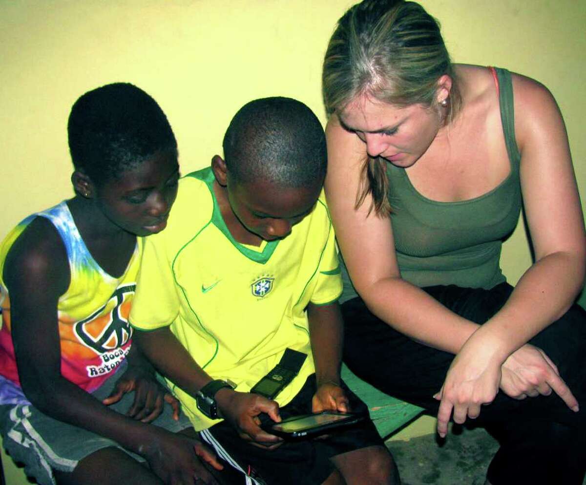 SPECTRUM/Augustina, left, and Jeffrey, students in Abokobi, Ghana, are shown how to use an e-Reader by Kristin Collins of New Milford. 2011. Courtesy of Kristin Collins