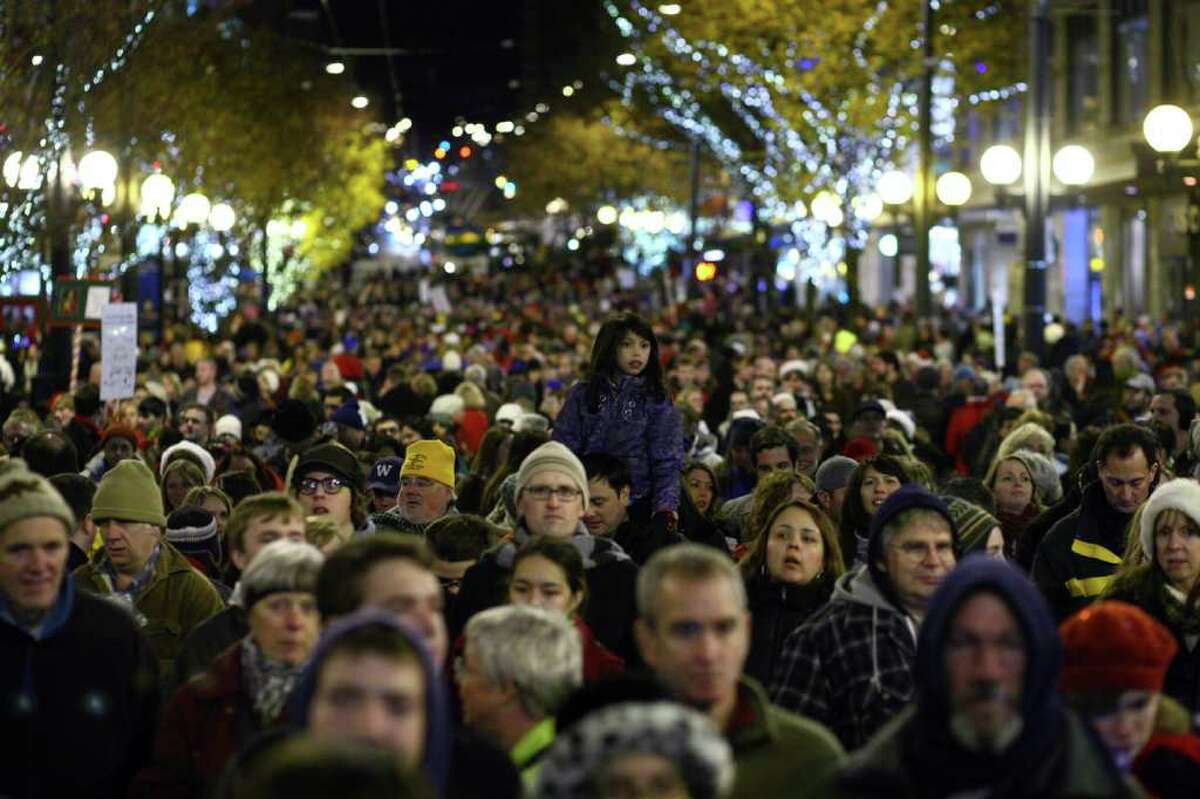 Spectators line Pine Street during the 25th annual Great Figgy Pudding street corner caroling competition on Friday, December 2, 2011 in downtown Seattle. The event is a fundraiser for the Pike Market Senior Center & Downtown Food Bank.