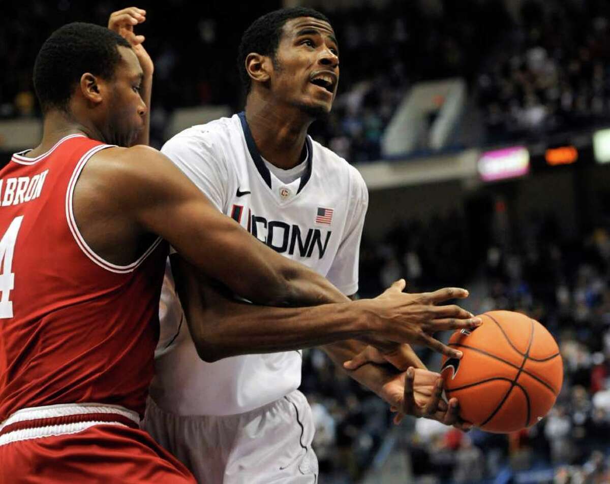Connecticut's DeAndre Daniels, right, is fouled by Arkansas' Devonta Abron, left, as he drives to the basket in the first half of an NCAA college basketball game in Hartford, Conn., Saturday, Dec. 3, 2011. (AP Photo/Jessica Hill)