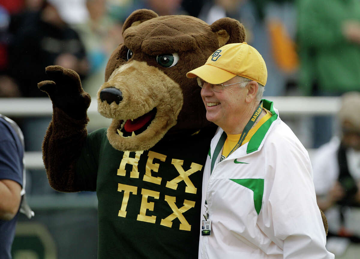 Baylor University president Ken Starr (right) poses with the university mascot before the start of an NCAA college football game against Texas, Saturday, Dec. 3, 2011, in Waco.
