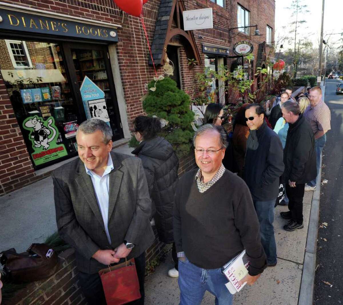 At left, Steve Schroeder, of Redding, Pa., and Greenwich resident Frank D'Angelo, right, wait in line to meet Greenwich resident Regis Philbin during a book-signing by Philbin at Diane's Books in Greenwich, Saturday afternoon, Dec. 3, 2011. Philbin was at the store to promote his new memoir, "How I Got This Way."