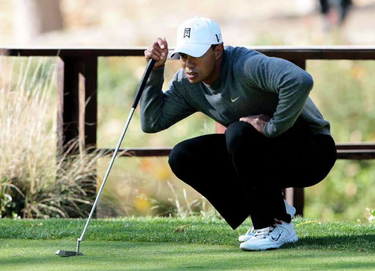 Tiger Woods lines up a putt on the third green during the third round of the Chevron World Challenge.