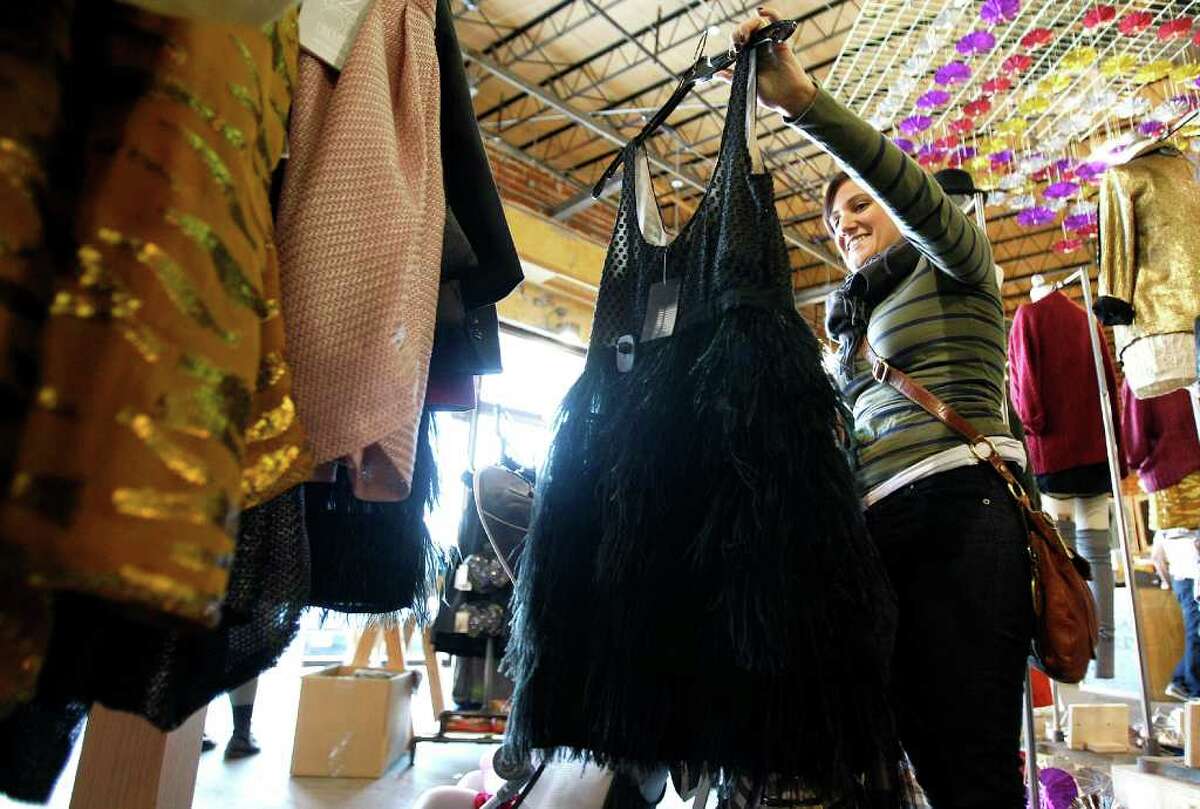 Tracy Flanagan looks at a black feather dress at Urban Outfitters. Other retailers — including Zappos, Forever 21 and Kohl’s — are offering retro clothing during the holiday shopping season.