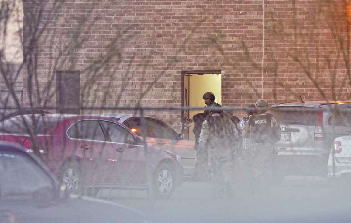 Members of the Laredo Police Department SWAT Team enters the Texas Department of Health and Human Services Offices through the south entrance during a hostage situation where a woman kept her two children and a employee hostage for several hours Monday.