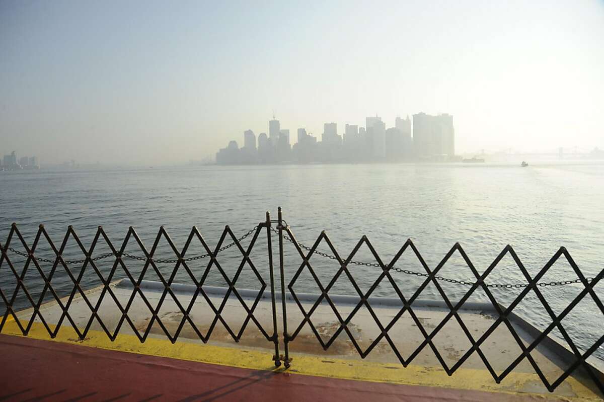 Haze shrouds the New York City skyline as the Staten Island Ferry –John F. Kennedy” makes its way toward Manhattan in the early morning hours of Friday, July 22, 2011. Afternoon temperatures rose above 100 in the city, causing many New Yorkers to stay indoors and out of the stifling heat. (AP Photo/Staten Island Advance, Bill Lyons) NYC OUT; ONLINE OUT