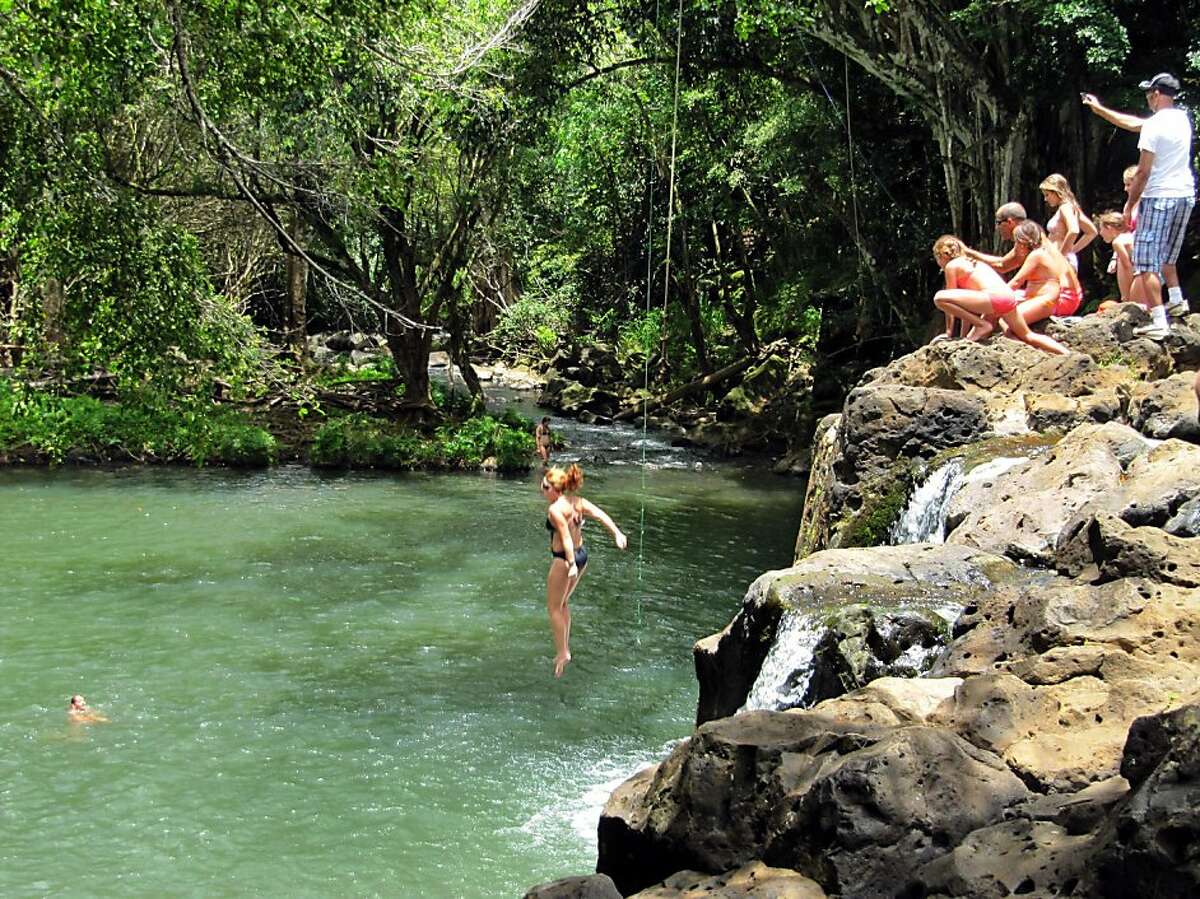 In a photo made July 6, 2011, a woman jumps into Kipu Falls in Lihue, Hawaii, on the island of Kauai. But the alluring beauty of the waterfall and natural pool conceals a deadly side. Five visitors to Kauai, all male, have drowned at Kipu Falls in the past five years.