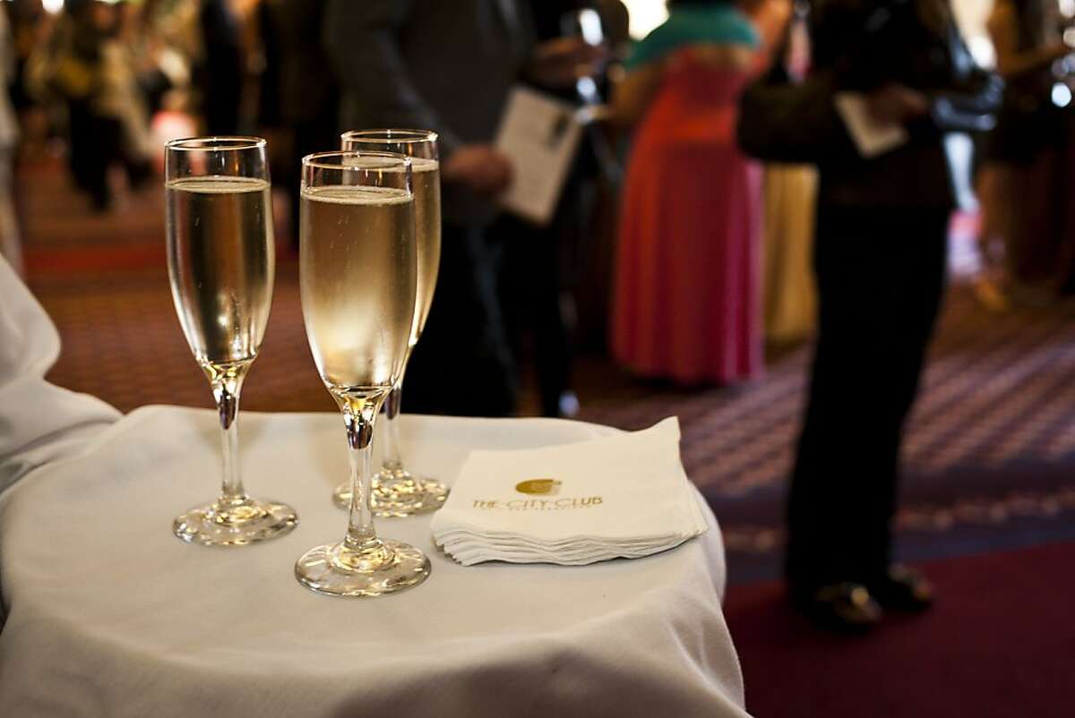 FILE - A waiter holds glasses of champagne at a San Francisco gala. 