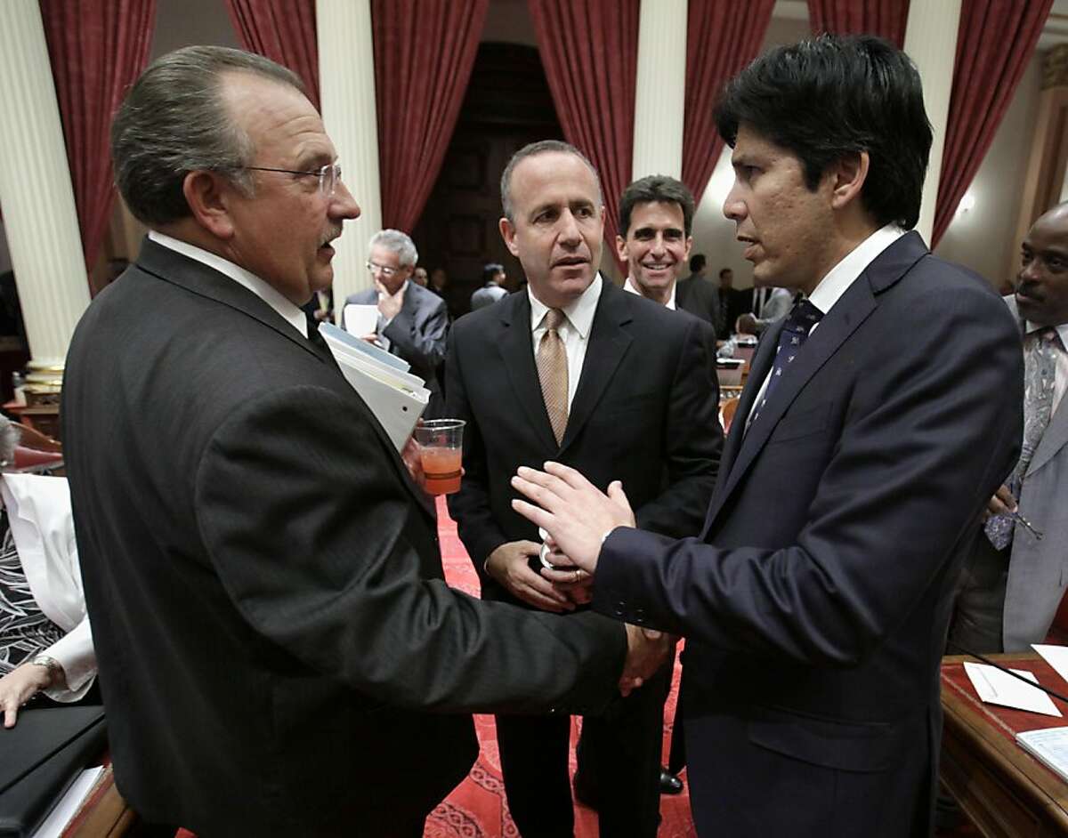 In a file photo, Sen. Kevin deLeon, D-Los Angeles, right, shakes hands with Senate Minority Leader Bob Dutton, R-Rancho Cucamonga, as Senate President Pro Tem Darrell Steinberg, D-Sacramento, looks on. Sen. Kevin deLeon proposed the legislation over whether gun owners should be required to appear in person and be fingerprinted before being allowed to buy ammunition.