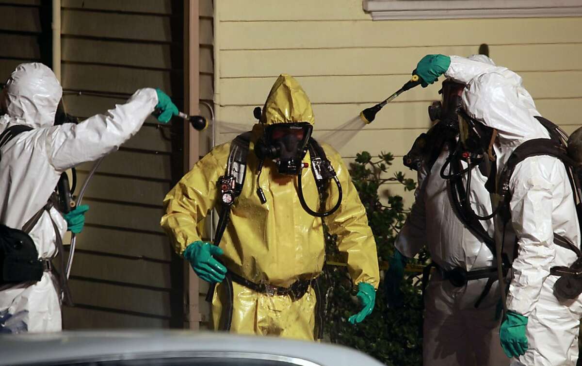 Fellow Belmont FD Hazmat team members clean off firefighter Steven Scott from the Belmont Fire department after responding to a toxic spill at a home on Baden Ave in South San Francisco Tuesday December 6, 2011.