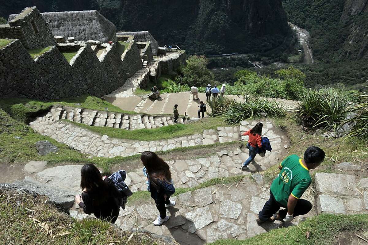 Tourists walk among the ruins of the Machu Picchu citadel, on July 5, 2011. The Inca citadel is being prepared for the centennial commemoration of its discovery by American adventurer and archaeologist Hiram Bingham in 1911. The compound, which sits at 2,350 meters above sea level in the heart of the Urubamba valley in southern Peru, 510 kilometers south of Lima, remained unknown to Spanish conquerors and is now visited by up to 250,000 a year.