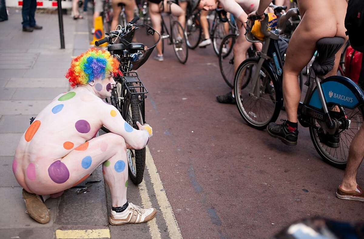 A man repairs a puncture as he takes part in the annual "London World Naked Bike Ride" event in central London on June 11, 2011. Now in it's eighth year, the event has seen participation grow from 58 in 2004 to 1,200 in 2009. Taking a route that passes many of London's most famous landmarks, the ride allows those participating to decorate their body with messages of protest against oil dependancy and motor vehicle usage. AFP PHOTO/Leon Neal (Photo credit should read LEON NEAL/AFP/Getty Images)
