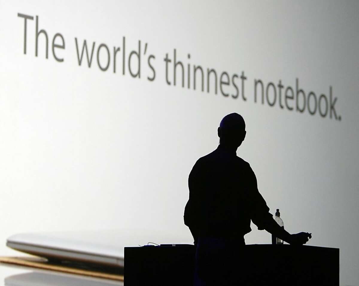 Apple CEO Steve Jobs watches an advertisement for the MacBook Air during his keynote address to open the annual Macworld conference in San Francisco, Calif. on Tuesday, Jan. 15, 2008. Jobs announced upgrades to the iPhone and iTouch and introduced the new MacBook Air and Time Capsule.