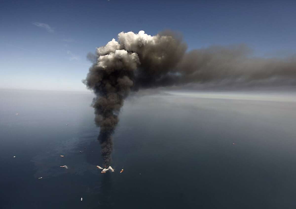 This Wednesday, April 21, 2010 file photo shows oil in the Gulf of Mexico, more than 50 miles southeast of Venice on Louisiana's tip, as a large plume of smoke rises from fires on BP's Deepwater Horizon offshore oil rig. An April 20, 2010 explosion at the offshore platform killed 11 men, and the subsequent leak released an estimated 172 million gallons of petroleum into the gulf.