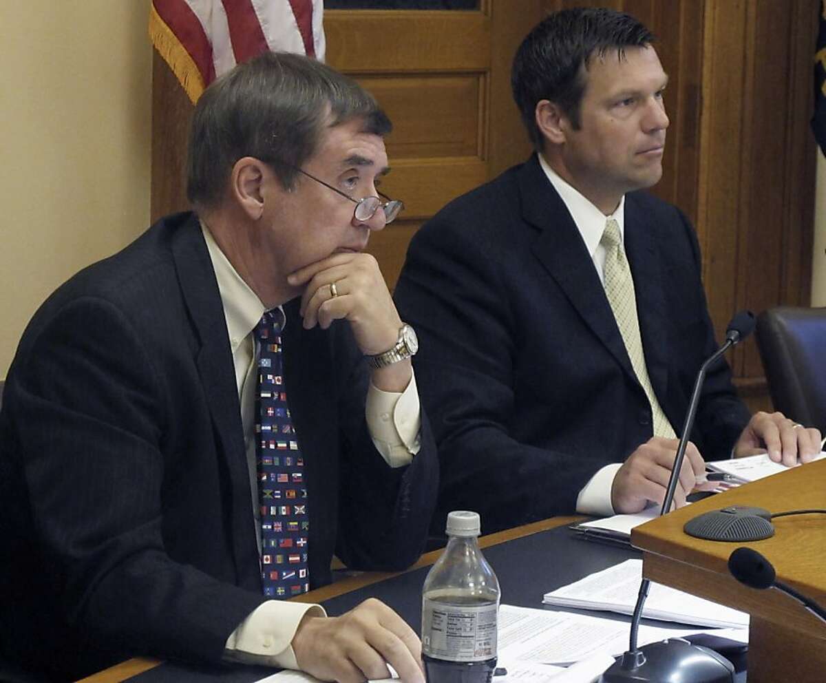 Kansas Secretary of Administration Dennis Taylor, left, and Secretary of State Kris Kobach, right, listen to a presentation on new regulations for abortion clinics, Thursday, June 30, 2011, at the Statehouse in Topeka, Kan. Taylor and Kobach are members of the State Rules and Regulations Board, which is allowing the regulations to take effect on Friday, July 1, 2011. Planned Parenthood disclosed Thursday that its Kansas clinic had been denied a state license to continue performing abortions as the group filed its own lawsuit to block new state rules that will make Kansas the first state in the nation without an abortion provider.