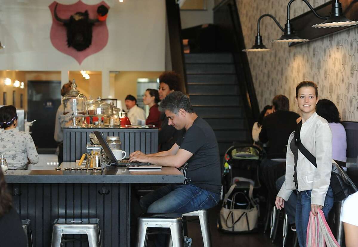 Cameron Reje (center) works on his computer at Jane Cafe on June 24, 2011.