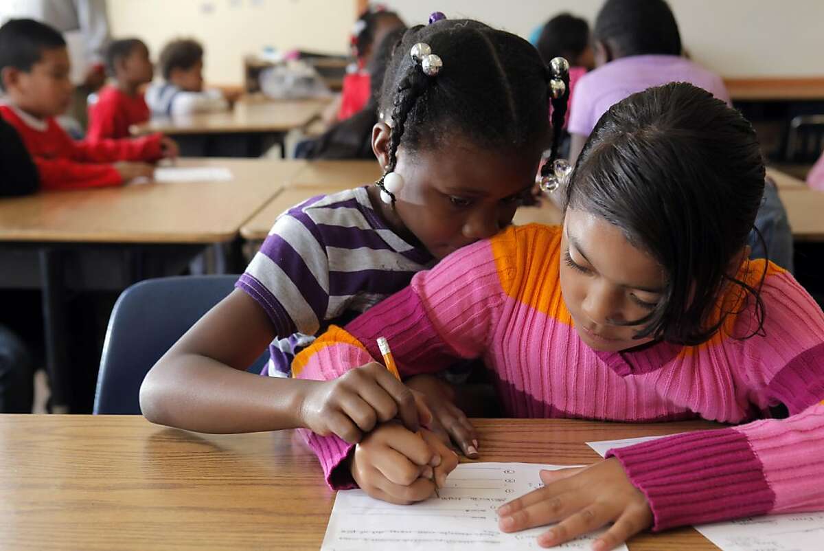 Keiara Franklin, left, helps her classmate, Nellie Gaoteote with a school assignment during a summer school program at John Muir Elementary School in San Francisco, Calif., on Wednesday, June 29, 2011.