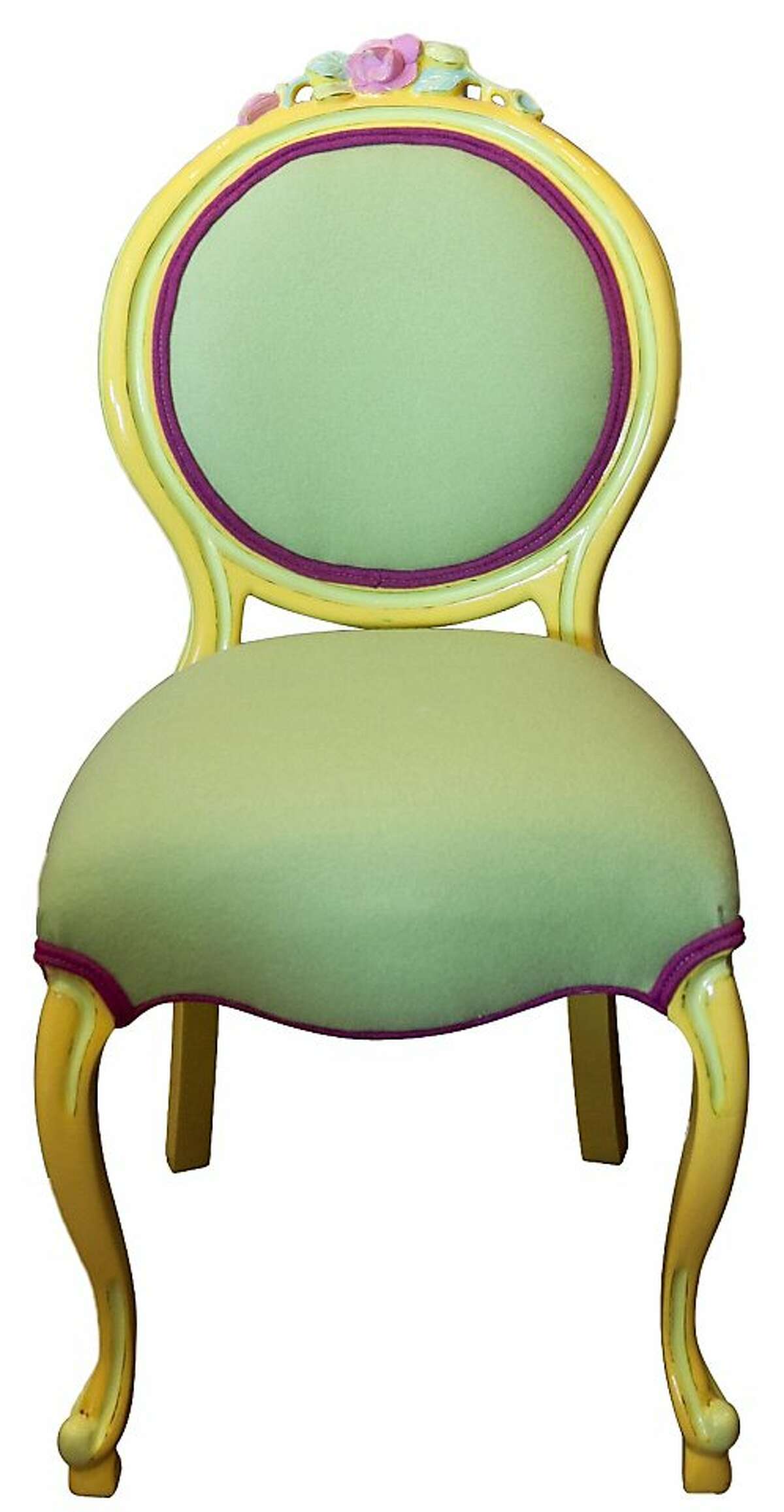 Furniture restoration expert Carolyn Pickell (not pictured) partnered with Cypress Furniture to refurbish the sherbert colored french style chair (Pickell painted it in lemon yellow, lime green and cotton candy pink while Cypress Furniture reuphostered the chair in matching lime green felt with fuscia trim). Above the chair is a mid-century lamb Pickell rewired, painted and topped off with an Edison bulb. On the left is a nightstand she painted, distressed the added a hand painted bird drawer pull while on the right stands a vintage telephone table she painted purple. Peeking through the flip top buffet is a work-in-progress while a teal painted turned leg table holds vintage books, a nest and feather baby owl in her shop, Side Furniture on San Pablo Av