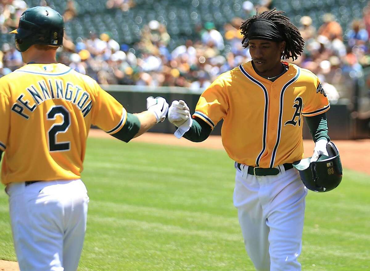 Jemile Weeks #19 of the Oakland Athletics celebrates with Cliff Pennington after scoring on a single by Coco Crisp against the Kansas City Royals at the Oakland-Alameda County Coliseum on June 16, 2011 in Oakland, California.