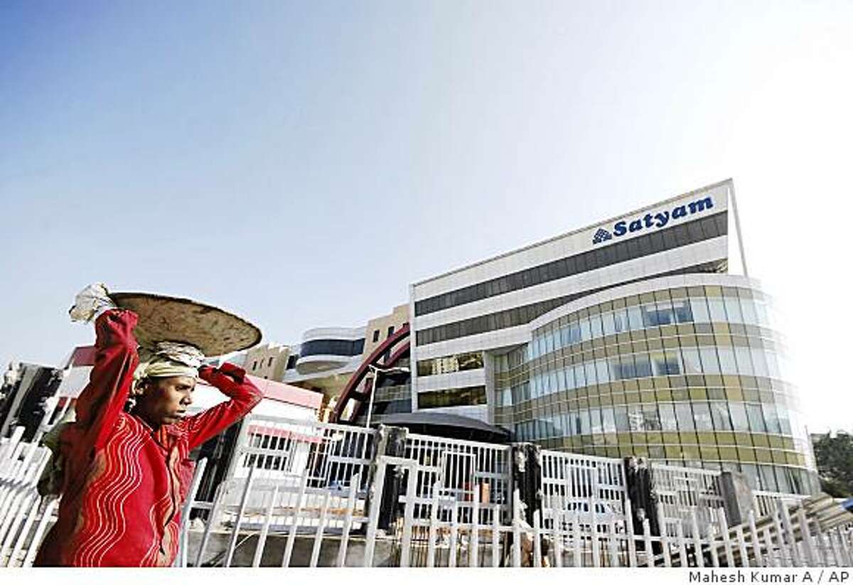 A laborer walks in the backdrop of the office of Satyam Infocity, the office of Satyam Computer Services Ltd., in Hyderabad, India, Wednesday, Jan. 7, 2009. The chairman of India's Satyam Computer Services Ltd. quit Wednesday after admitting the company's profits had been doctored for several years, shaking faith in the country's corporate giants as shares of the software services provider plunged nearly 80 percent. (AP Photo/Mahesh Kumar A.)