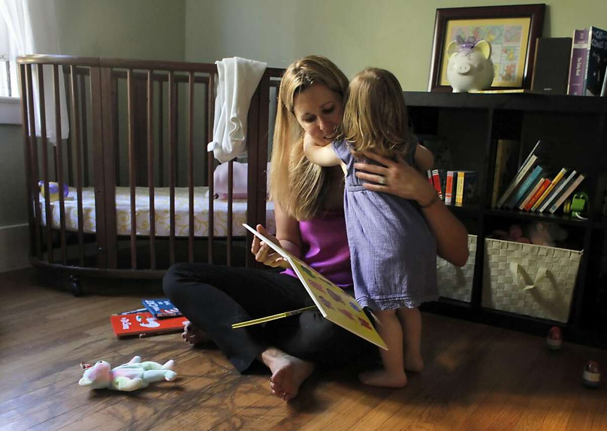 Suzanne Galvin gets a hug from her daughter Lily after they read together, Wednesday June 15, 2011, in Oakland, Calif
