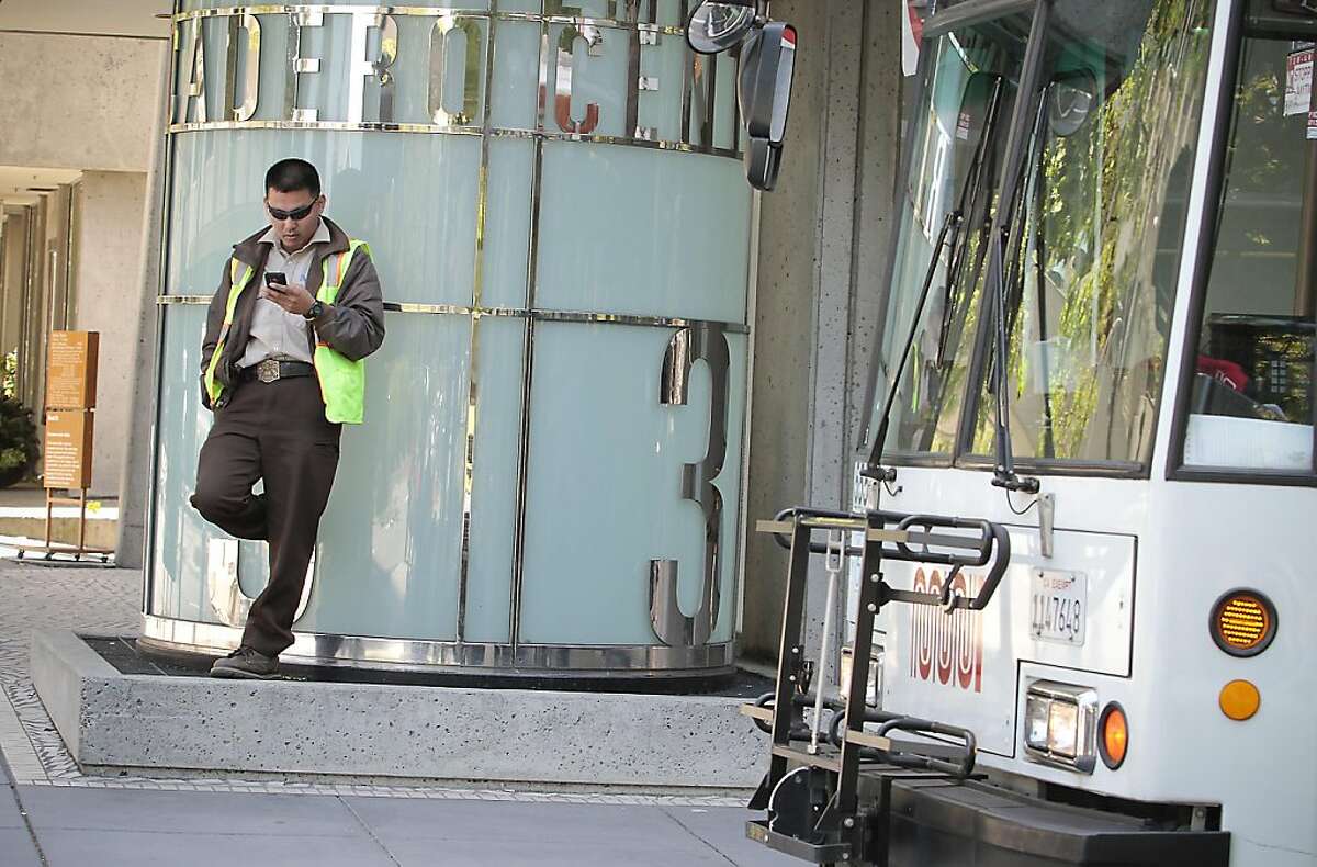 A Muni bus driver looks at his phone while taking a break at Clay and Drumm streets in San Francisco. San Francisco Municipal Transit operators vote on ratification of a new contract in San Francisco, Calif., on June 8th, 2011.