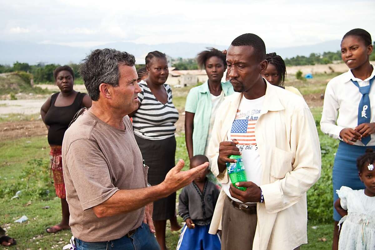 Sherman Balch, CEO of Extollo International, explains details to a Haitian translator about rebuilding the orphanage at the Dezman Fleury Foundation property.