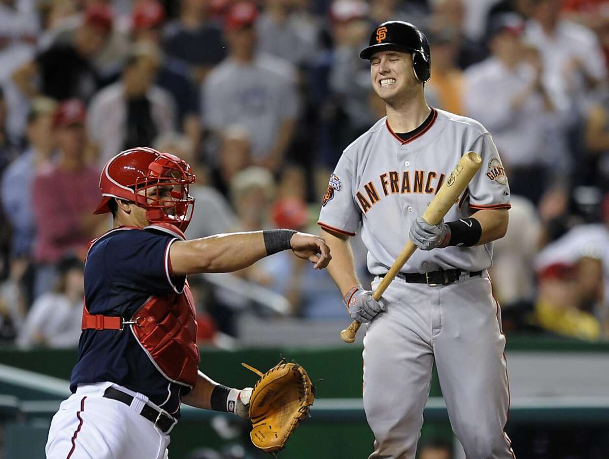 San Francisco Giants' Buster Posey, right, reacts as he bats during the ninth inning of a baseball game, as Washington Nationals catcher Wilson Ramos returns the ball to the pitcher, Monday, May 2, 2011, in Washington. The Nationals won 2-0.