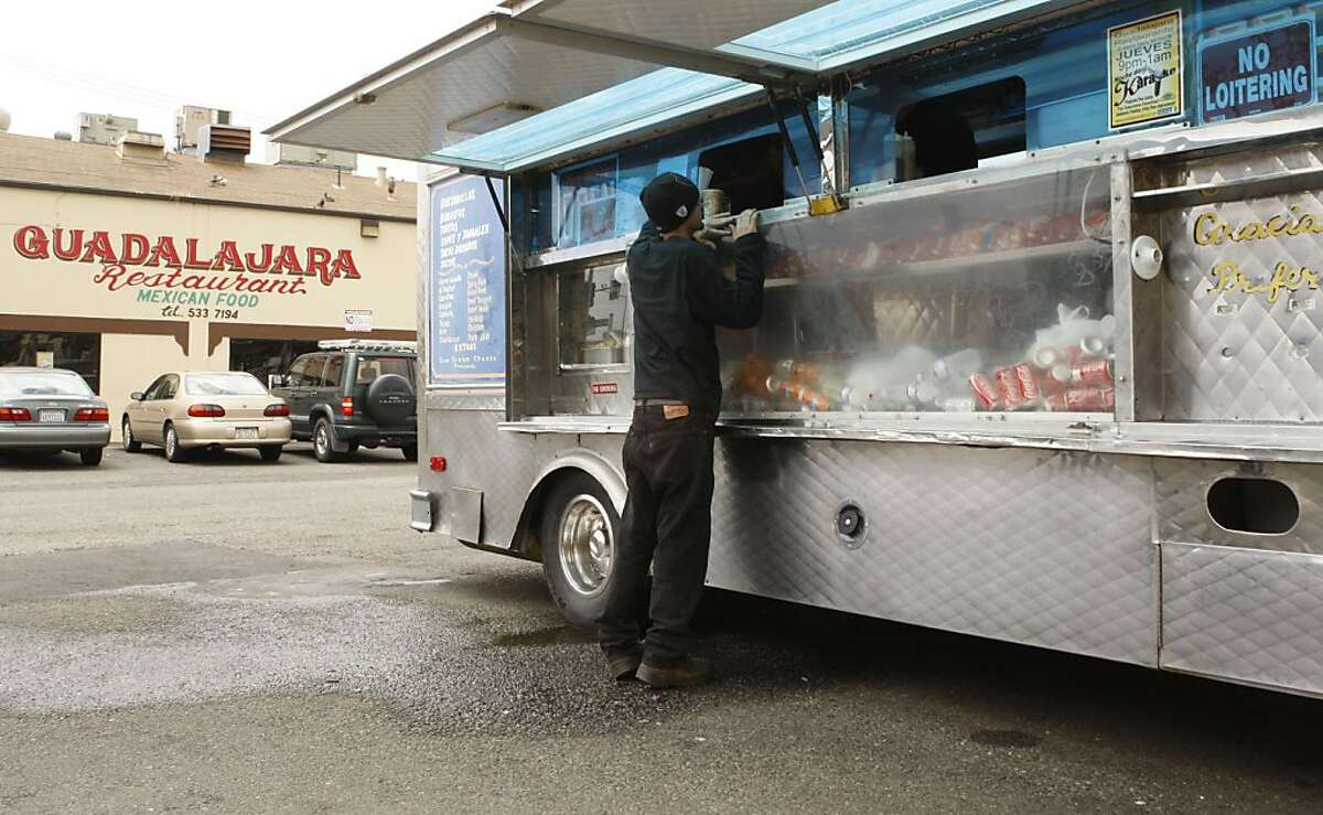A hungry customer places an order at the El Novillo taco truck in the parking lot of the Guadalajara Mexican Restaurant in Oakland Calif, on May 27, 2011. The truck and restaurant are both owned by the Pelaya family which feels the food spots serve different kinds of clientele.