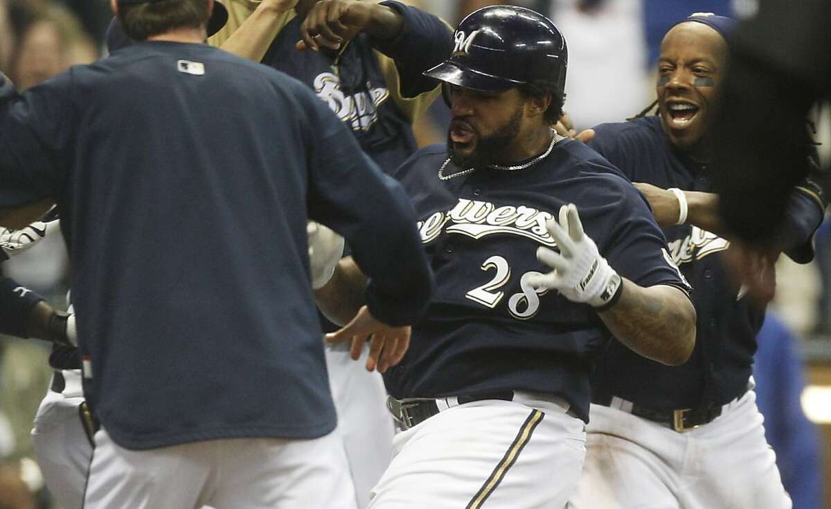Milwaukee Brewers' Prince Fielder is mobbed by teammates after hitting a two-run walk off home run during the 14th inning of a baseball game against the Colorado Rockies Friday, May 20, 2011, in Milwaukee.